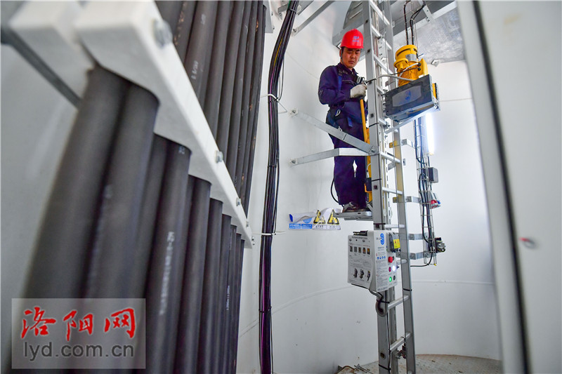 风电运维员烈日下高空作业挥洒汗水保供电高清图