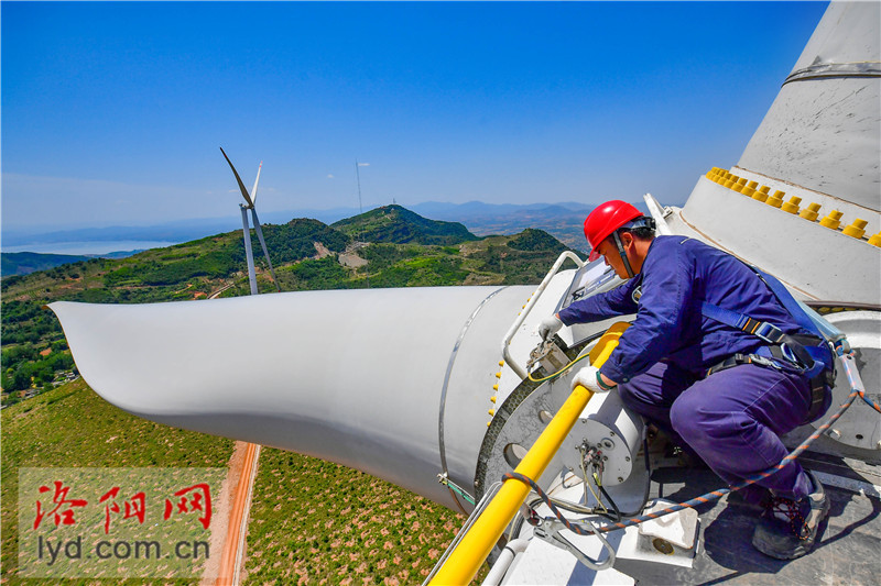 风电运维员烈日下高空作业挥洒汗水保供电高清图