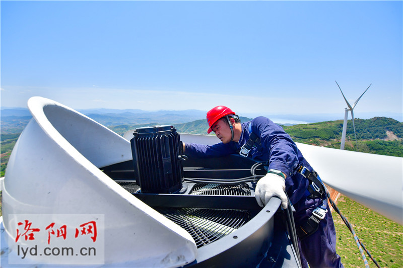 风电运维员烈日下高空作业挥洒汗水保供电高清图