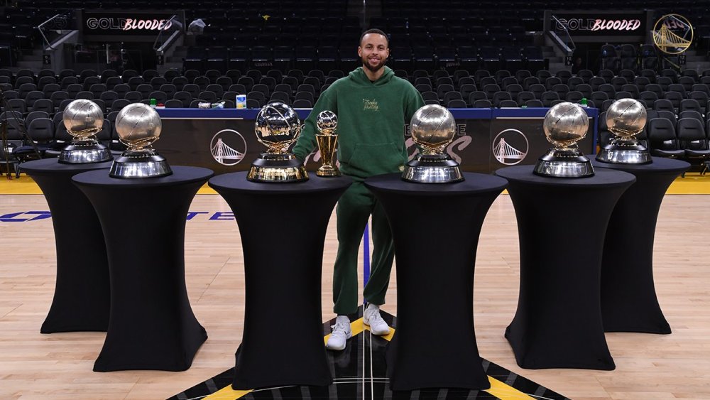 而在今天,库里晒出了一张霸气照,与7座奖杯的合影,其中有6个西部冠军