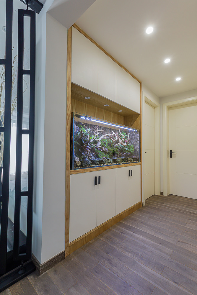 入户门做了一个到顶的鞋柜,中间镂空设计了一个鱼缸,增添了生命力.