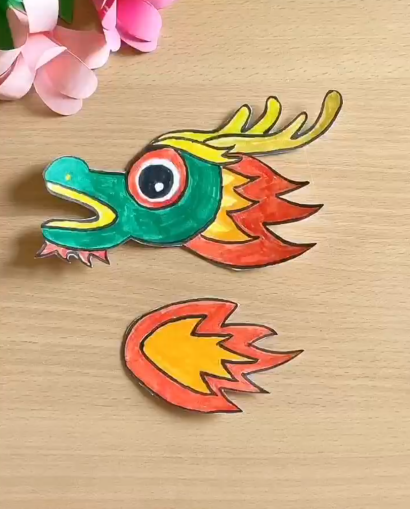 沿着所画线路,用剪刀将其剪下来再用黑色画笔进行描边将龙头和龙尾涂