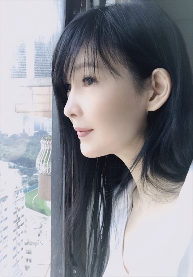 画面中的她皮肤白皙,一双大眼睛看向窗外仿佛会说话一般动人,而周慧敏