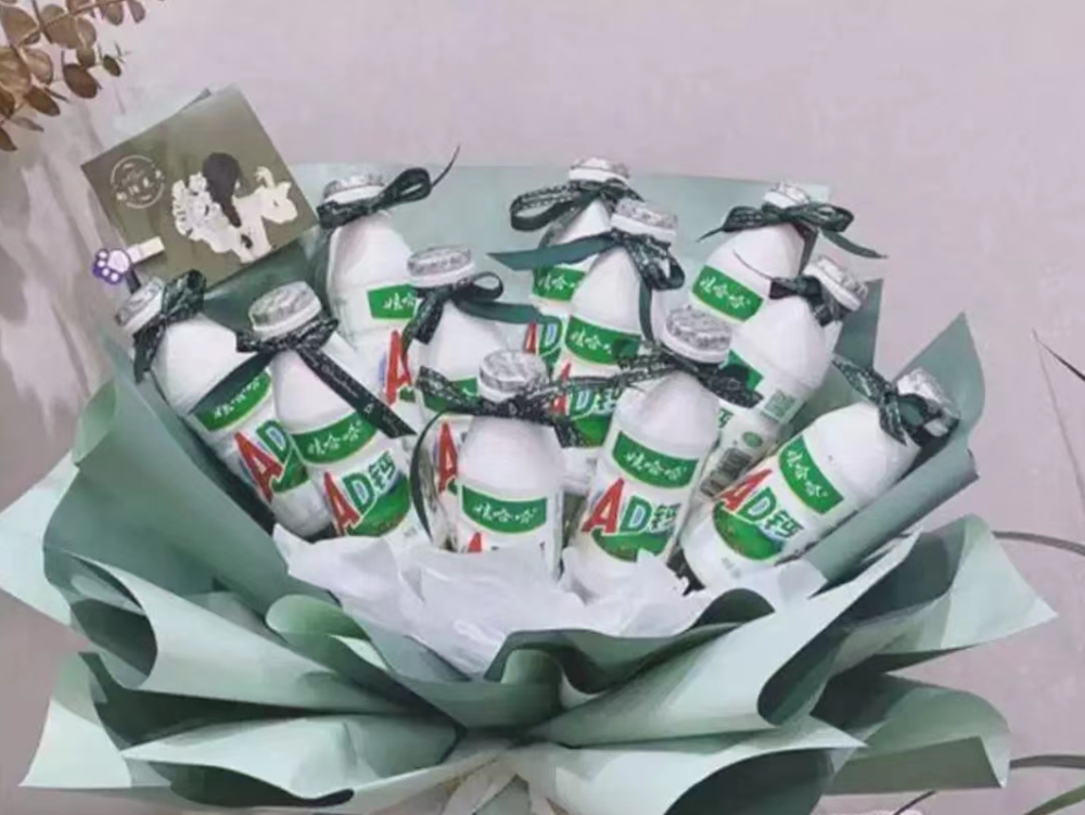 棒棒糖,娃哈哈,养乐多,巧克力各种零食被包装起来,和满天星等花放在一