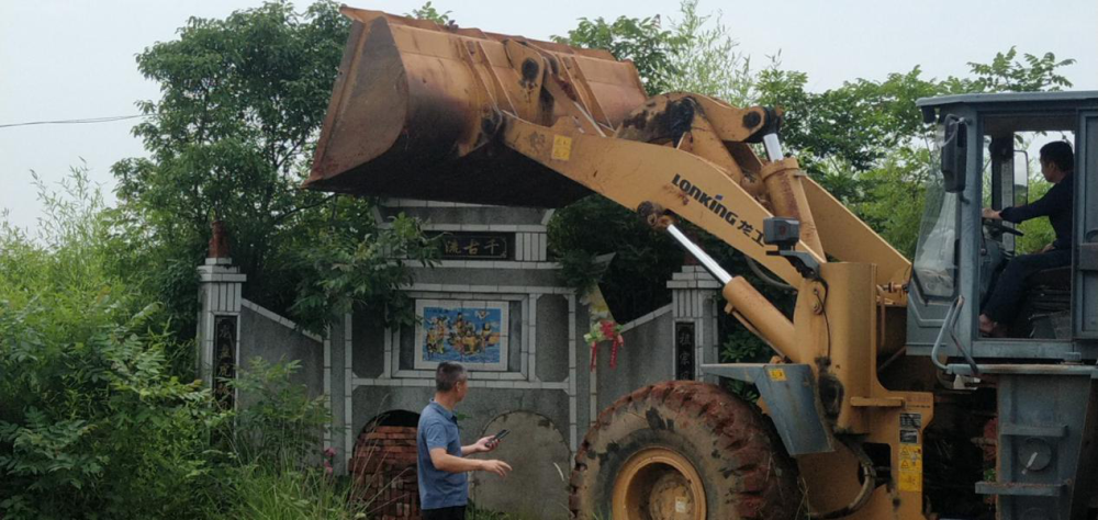 出動挖掘機2臺,工作人員10餘名,對兩座違法建造墳墓的水泥臺基進行