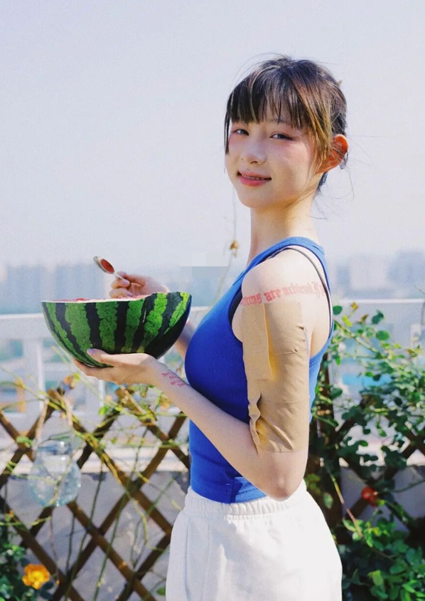 照片中痞幼上身穿蓝色的背心,秀出完美的直角肩,上围丰满身材姣好,下