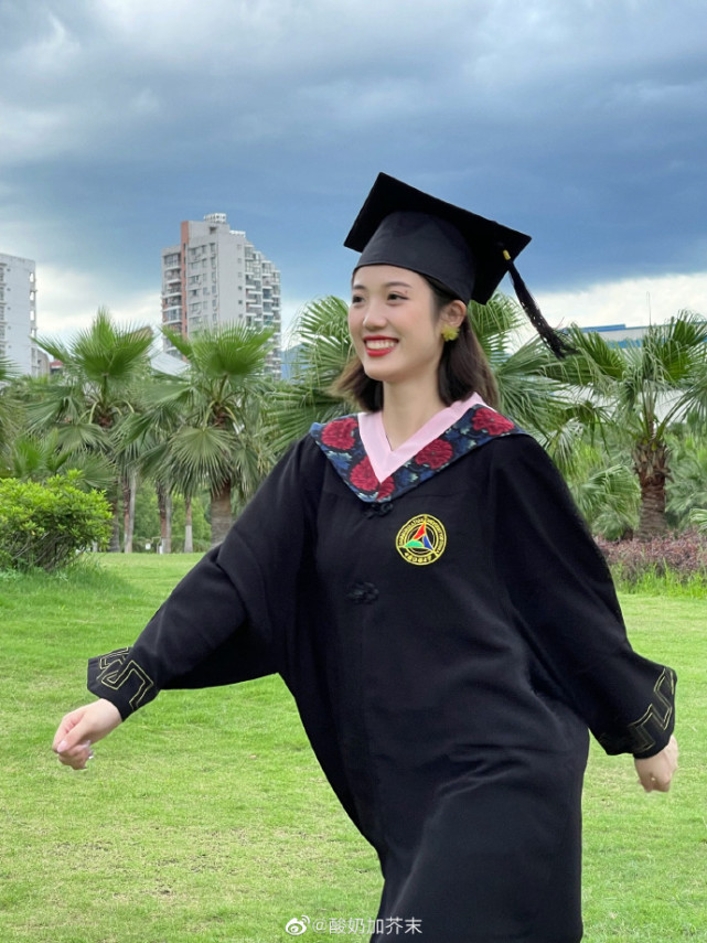 灿灿穿着学士服,戴着一顶学士帽,昂首阔步,迈向未来.