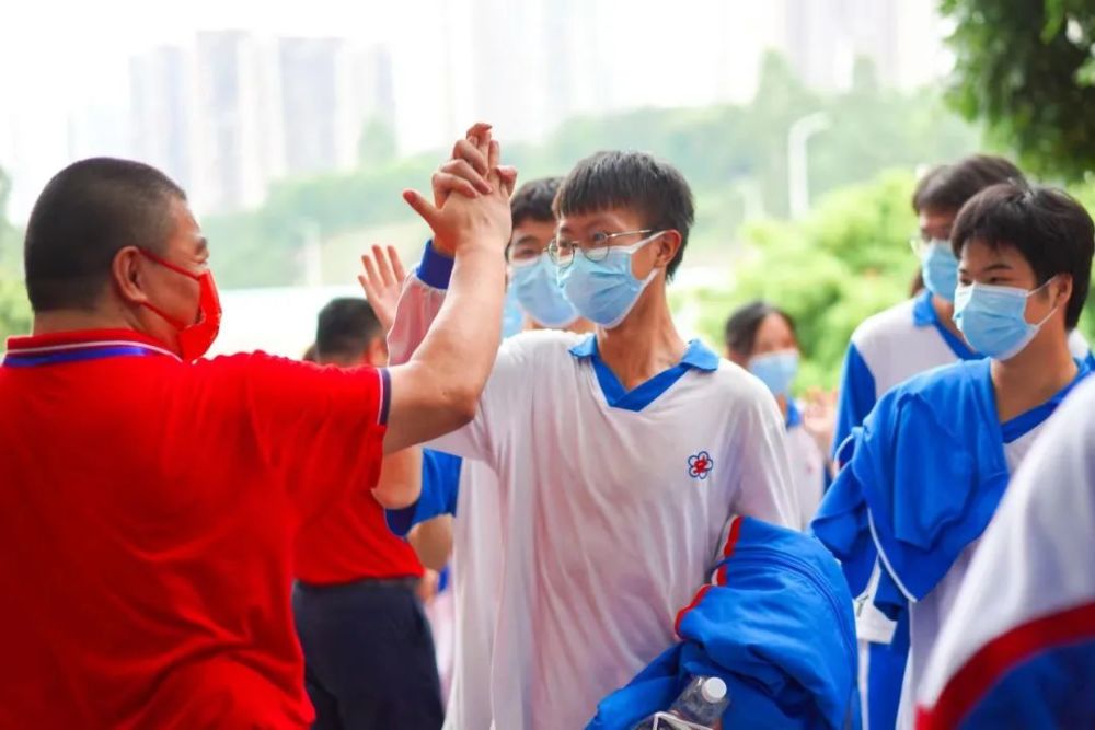 為沒帶雨傘的考生遮風擋雨午休時分廣州市玉巖中學的兩位老師冒著暴雨