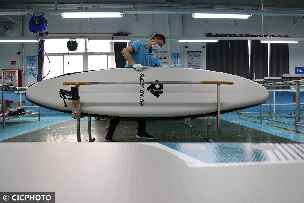 在山东省滨州市高新区一家企业生产车间内,工人在制作冲浪板