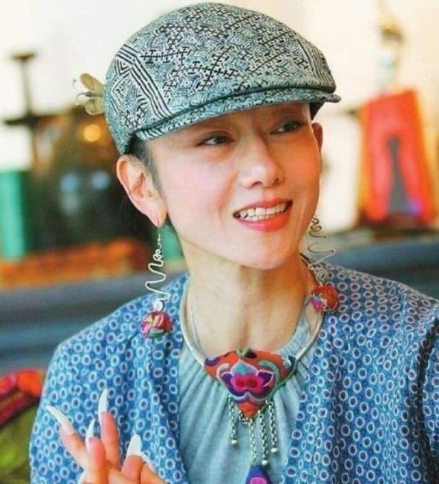 63岁杨丽萍秀手指舞双手修长插满鲜花一身白衣指甲太长太抢眼