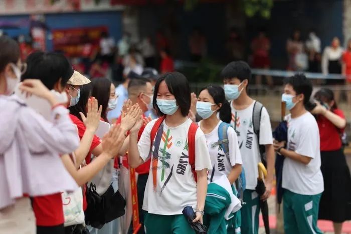 在考点门口,省实荔湾的校长和老师们与步入考点的学生们逐一击掌.