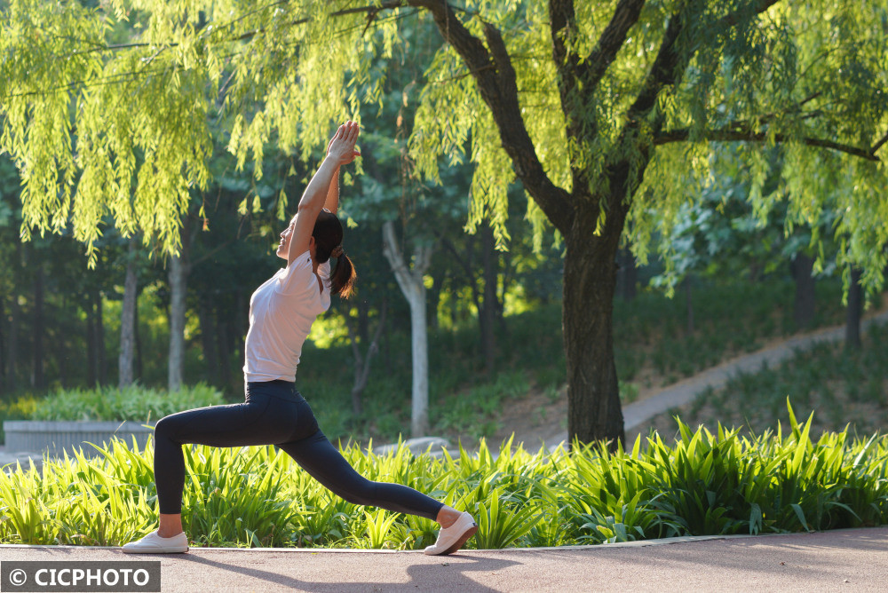 摄↑2022年6月21日,瑜伽爱好者在重庆市梁平区双桂湖国家湿地公园晨练