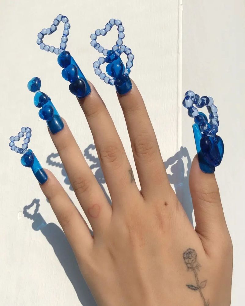 比如说新奇的结构,极具未来感的质地与色调,夸张的配饰,美甲上的"极繁