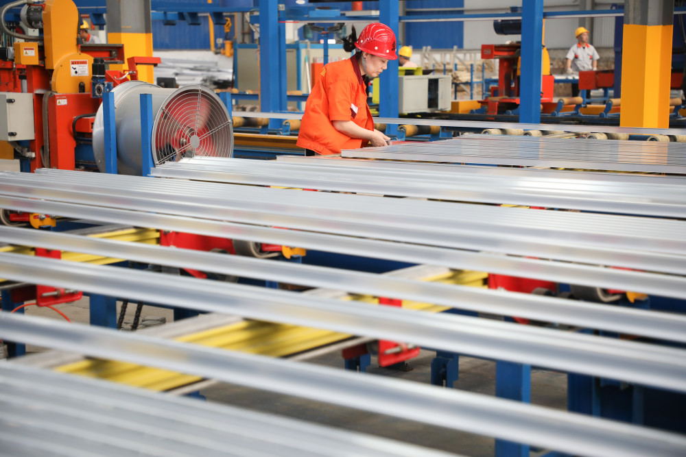 6月29日,在甘肃省定西市陇西县,一家铝箔公司员工在车间内忙碌.