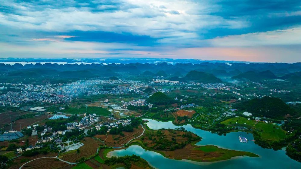 夏日,贞丰三岔河景区的画风转成了悠远的青峰山峦,恬静的远山湖水