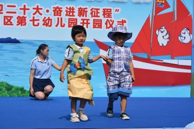 在幼儿环保服饰展环节,孩子们穿着家长和老师用米袋子,废旧报纸,环保