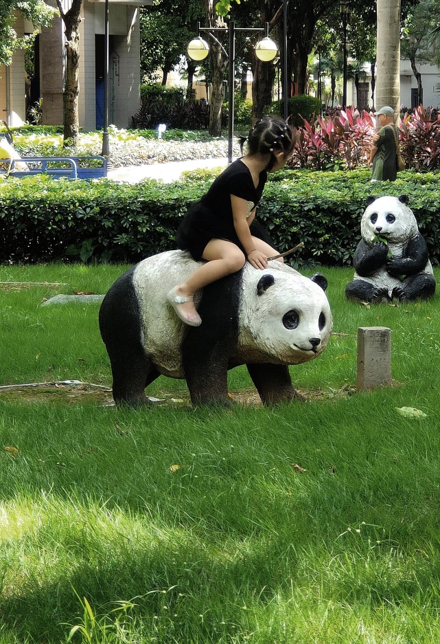 图23:2022年6月26日,广州市海珠区双塔路附近一小区内,骑熊猫的小孩.