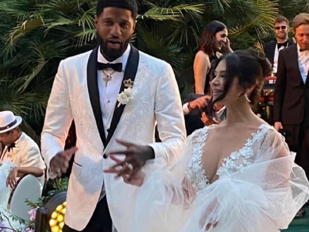 婚礼现场保罗乔治和妻子丹妮拉十指相扣,这对情侣已经走过了10个年头