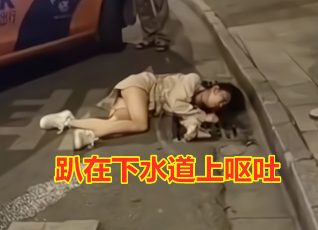 女子醉酒后趴在下水道呕吐因难受不停扭动身躯酒友不知去哪了