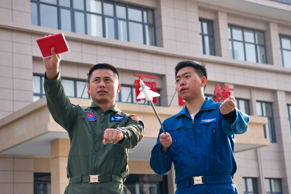 空军首批歼-10飞行学员在石家庄飞行学院某旅演练场与教官进行地面