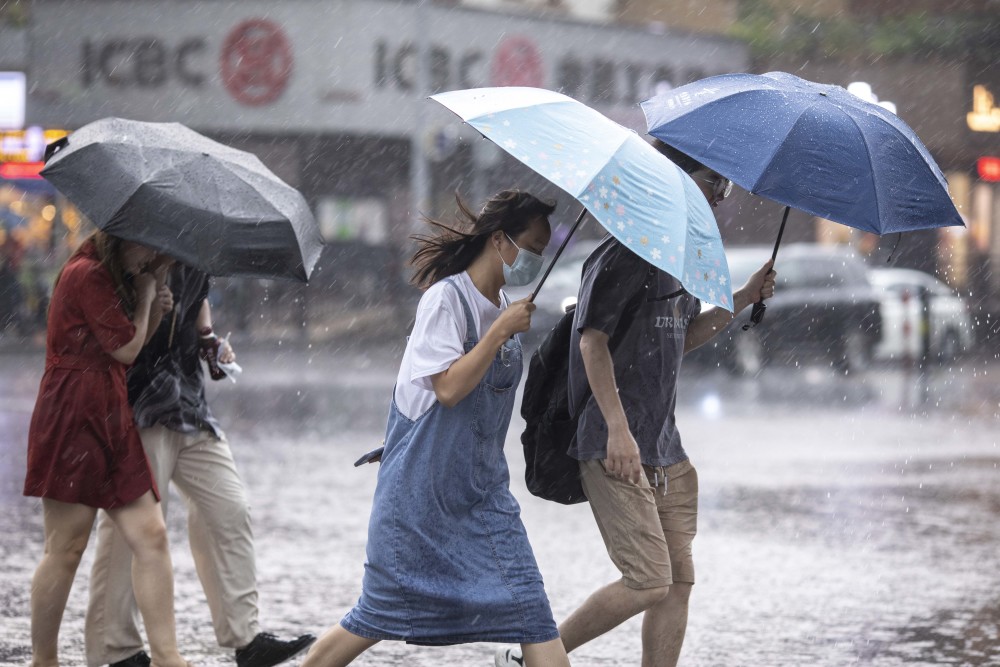 海珠区江南大道,路上行人在暴雨中很是狼狈,不少市民的伞被大风吹反.