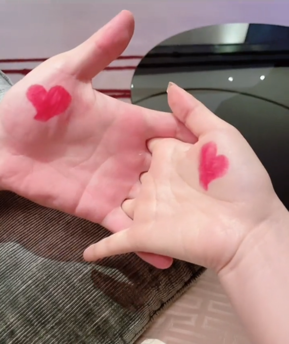 视频末尾,张馨予白皙的玉手因为与老公"十指紧扣",所以印上了爱心图案