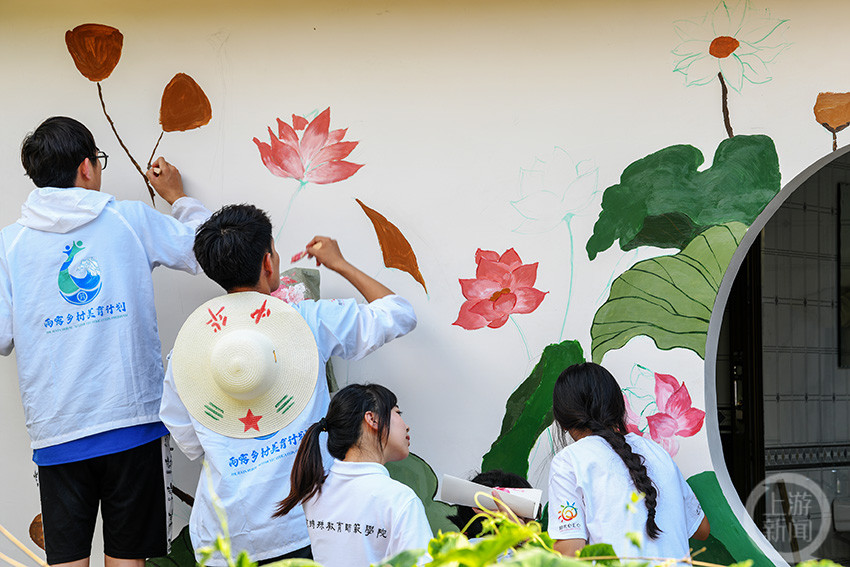 重庆酉阳大学生志愿者墙绘扮靓乡村