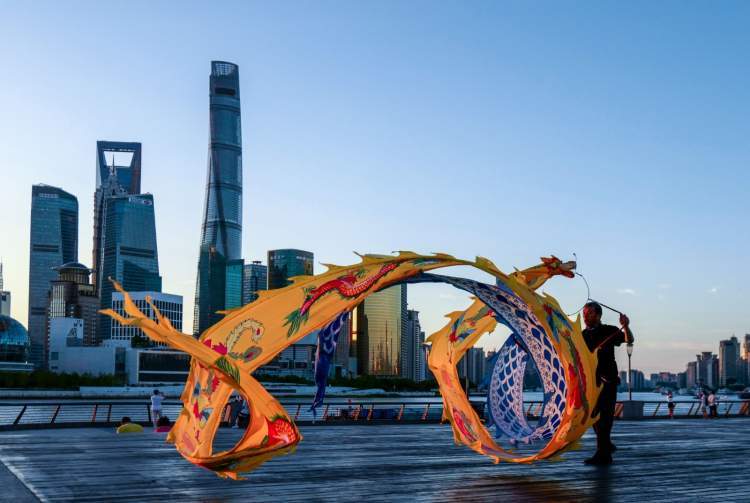 迎着初升的太阳手持彩龙当空舞晨镜头