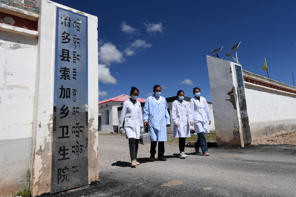 在治多县索加乡卫生院,布久索南更青(左二)和同事们一同走出卫生院