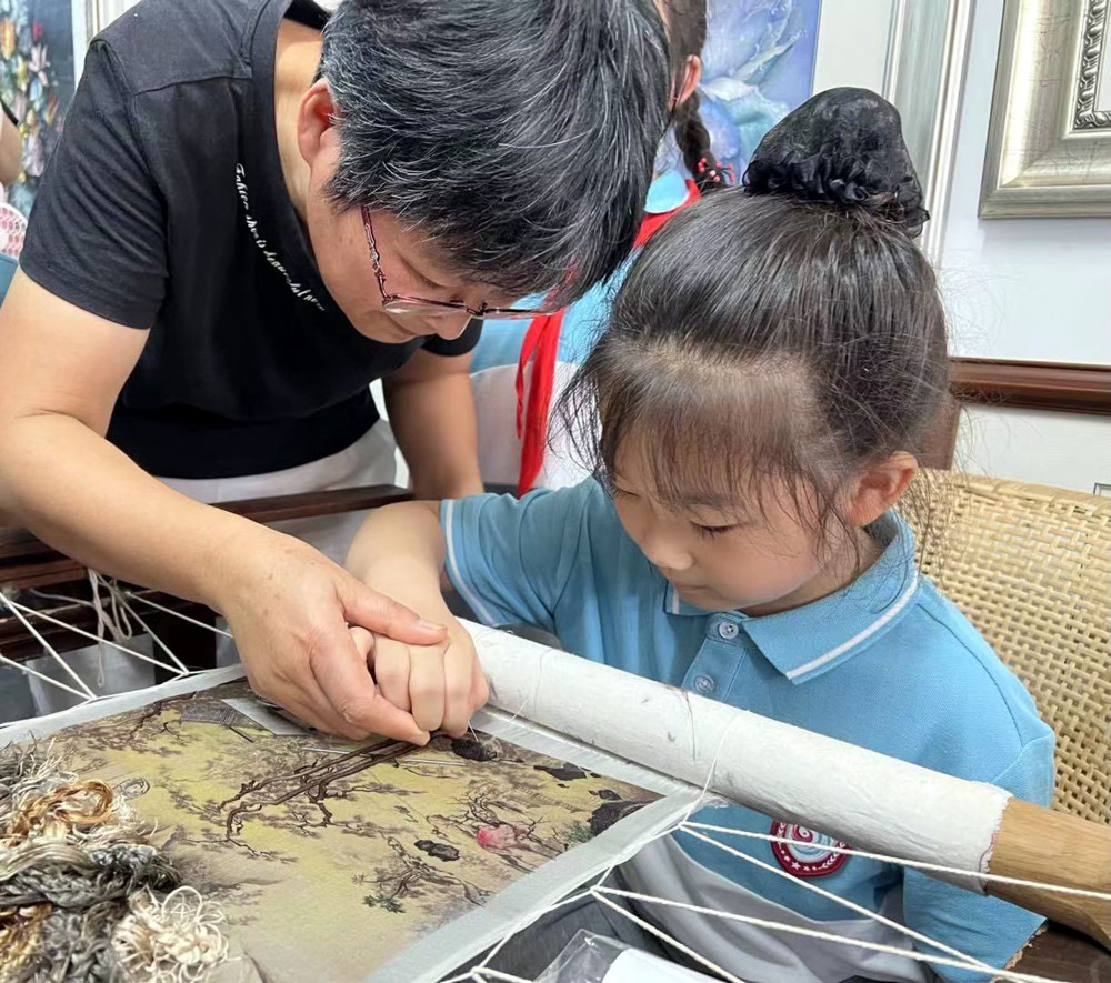 工作室,大家兴致勃勃地围在王老师身边,听王老师介绍镇湖刺绣的历史