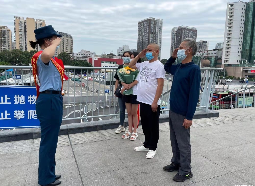 "一身戎装的退役女兵曾媛媛走出出站口,向迎接她的家人大声报告并敬了