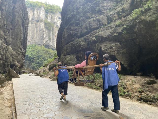 2022年8月29日,田应祥和罗时云在景区抬滑竿,游客与滑竿自重加起来约