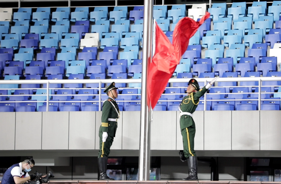 步履铿锵接过鲜红的国旗八名擎旗手从少先队员手中一声嘹亮的口令划破