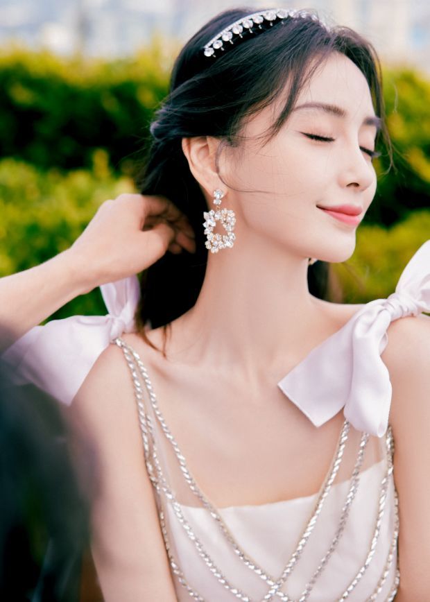 杨颖一袭白裙手持鲜花似花仙子对镜甜笑优雅迷人