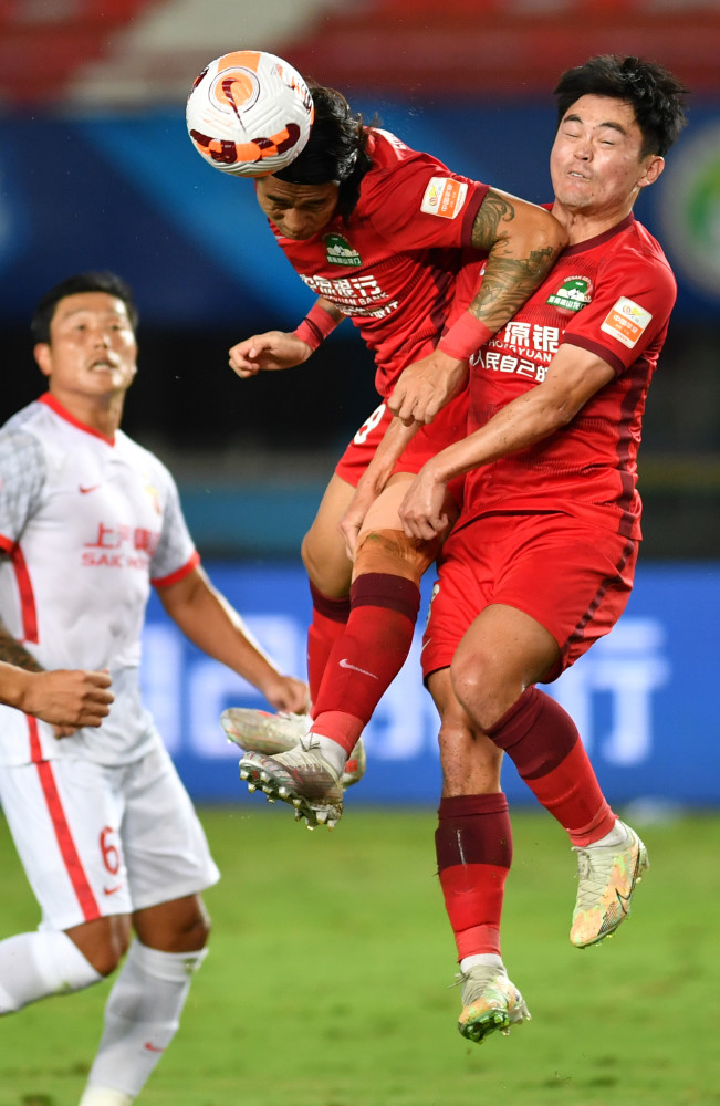 摄9月20日,河南嵩山龙门队球员赵宇豪(左)与上海海港队球员保利尼奥在