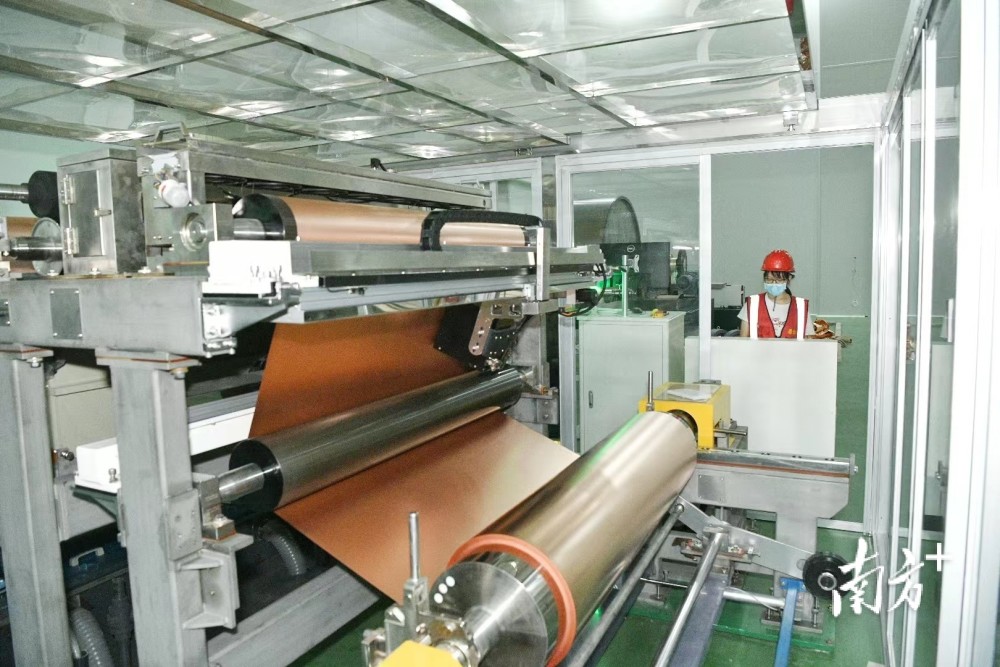 完成调试的一台台崭新的设备陆续开机运行,缓缓"吐"出玫瑰金色的铜箔