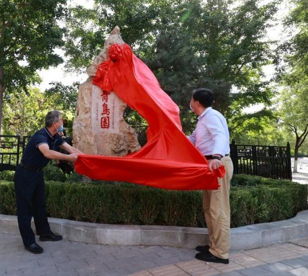 像新娘子揭盖头似的,红色的锦缎从一块石碑上缓缓拉开,石头上三个楷书