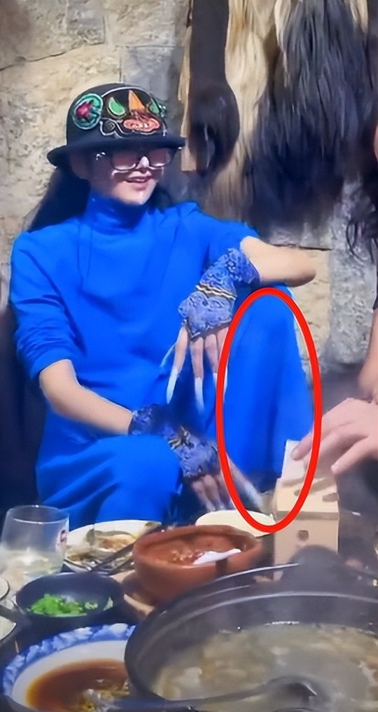 杨丽萍与亲友聚会吃火锅,脚踩凳子上姿势霸气,指甲超长动作不便