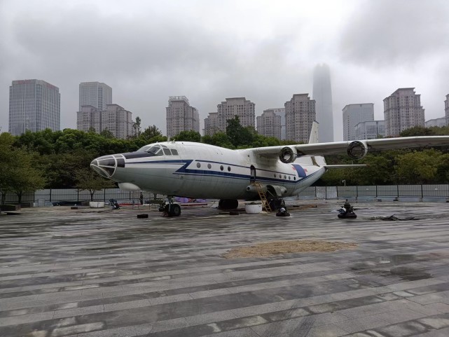 远远便可见一架飞机伸展着两个翅膀,停泊在公园内一角