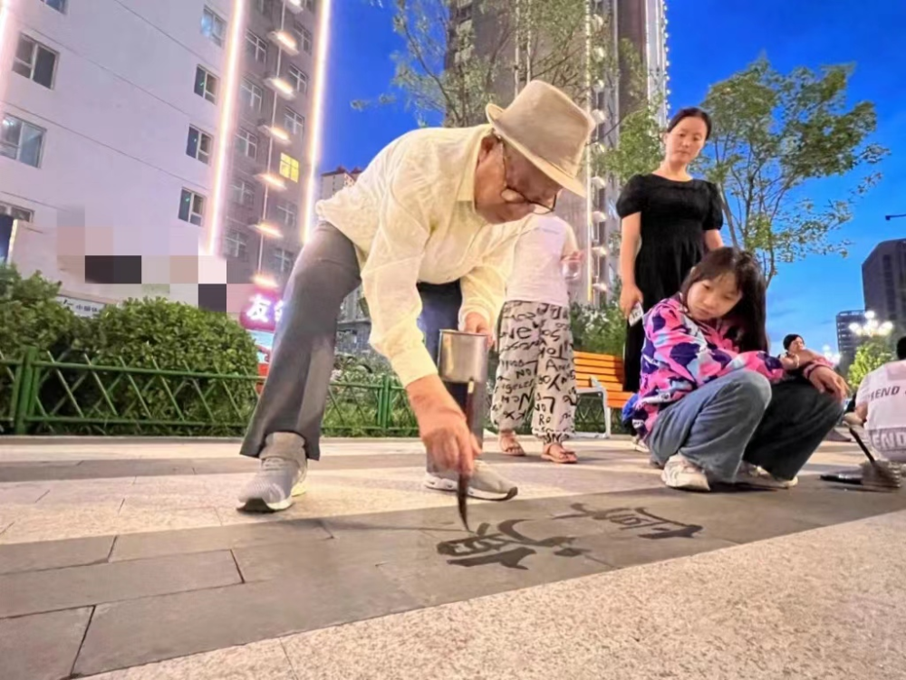 杨洪禄想到一种更为方便环保的练习方法:用毛笔蘸取清水在地砖上写字