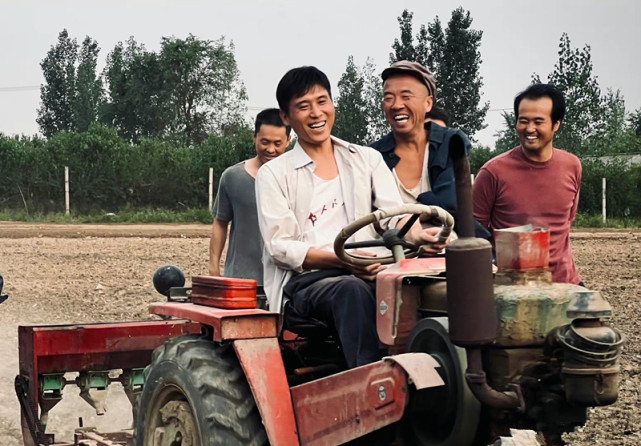 饰演的角色,正在驾驶一辆拖拉机,这种扮相,确实就是当年的农民形象