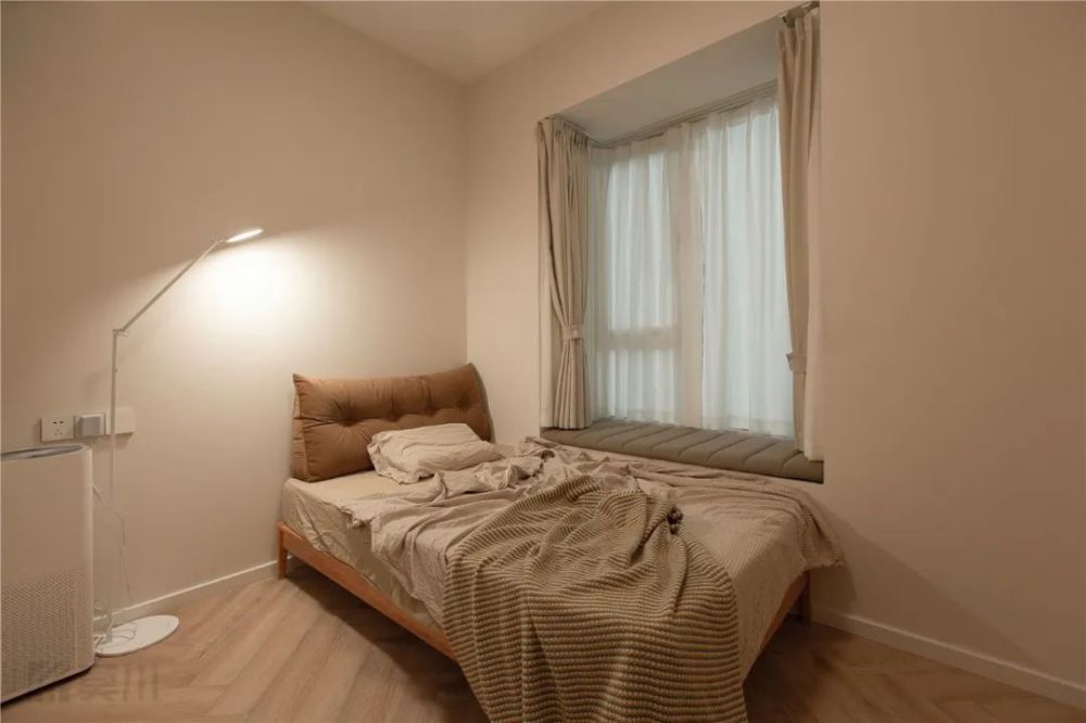 奶咖色的墙面空间,在床头旁边布置一盏落地灯,搭配朴素的床单,让次