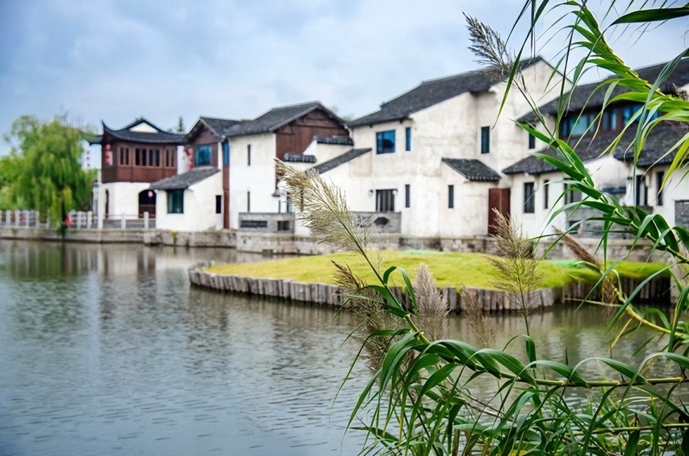 晨雾渐渐散去,植物的绿色也越来越鲜明开阔处的水域上,三两只渔船,数