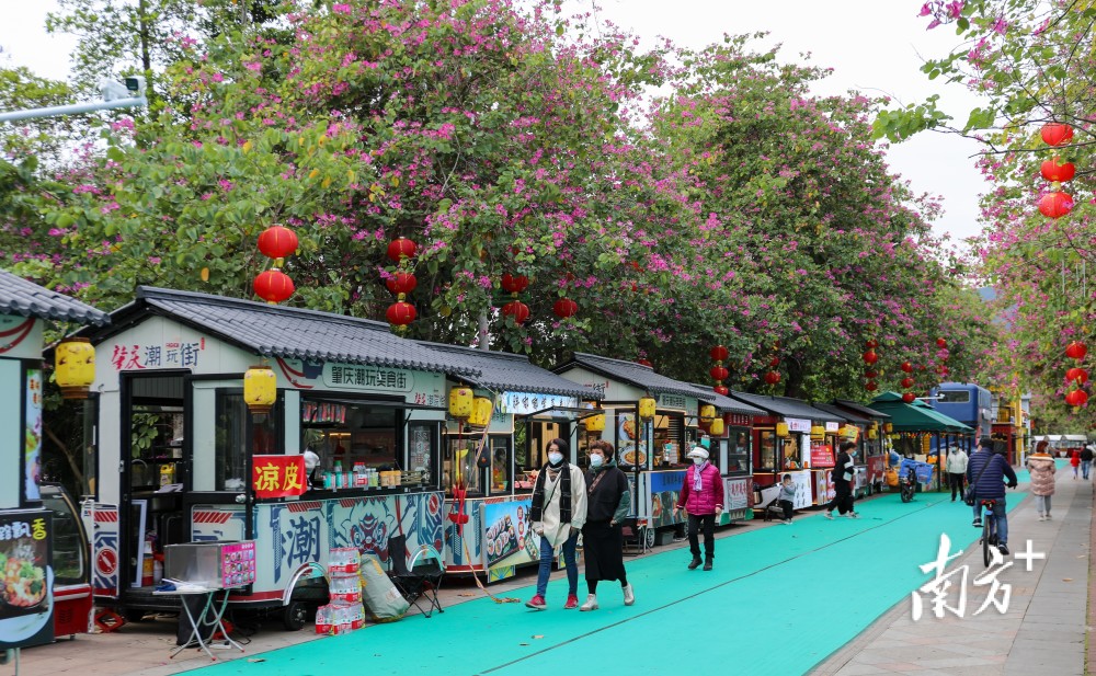 肇庆紫荆西堤文创街重新"开张".南方  施亮 摄买蛋糕的母子俩.