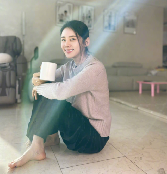 43岁秋瓷炫赤脚晒太阳,坐家中地板气质优雅,手拿咖啡十分惬意