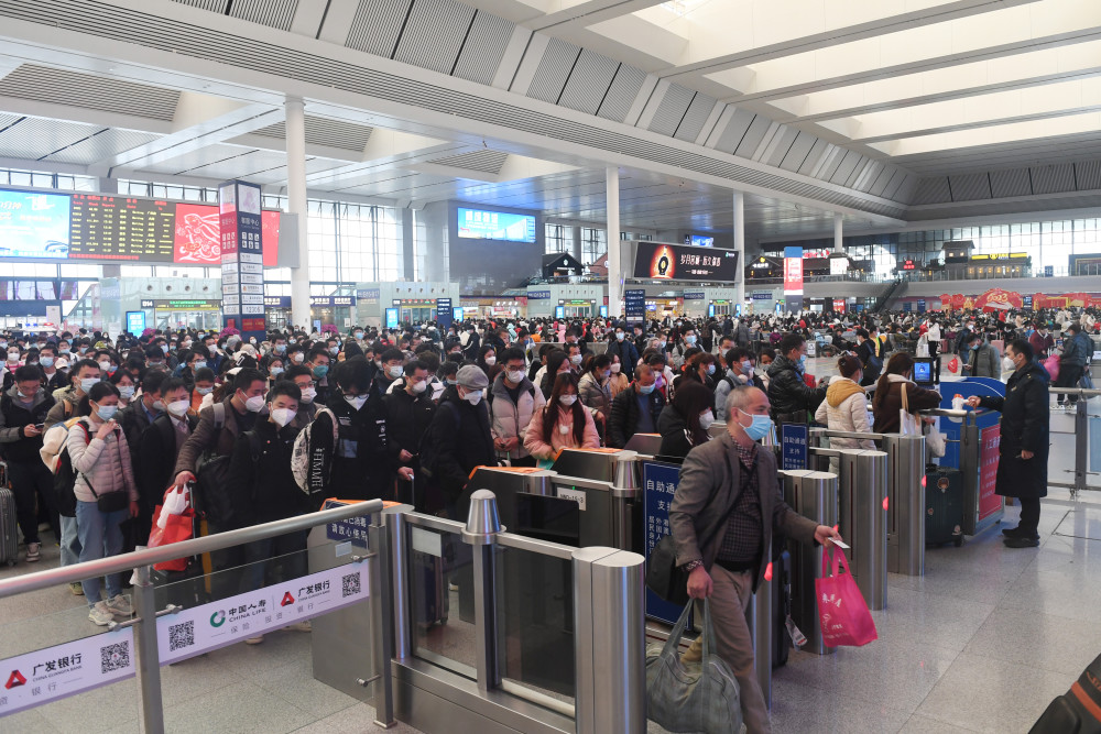 1月27日,旅客在南寧東站通過檢票口準備上車.