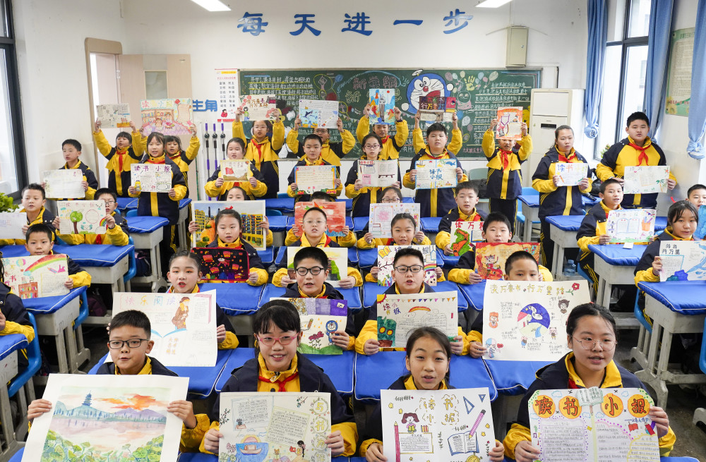 九龙坡区铁路小学五年级2班的学生在开学第一课上展示自己的手抄报和