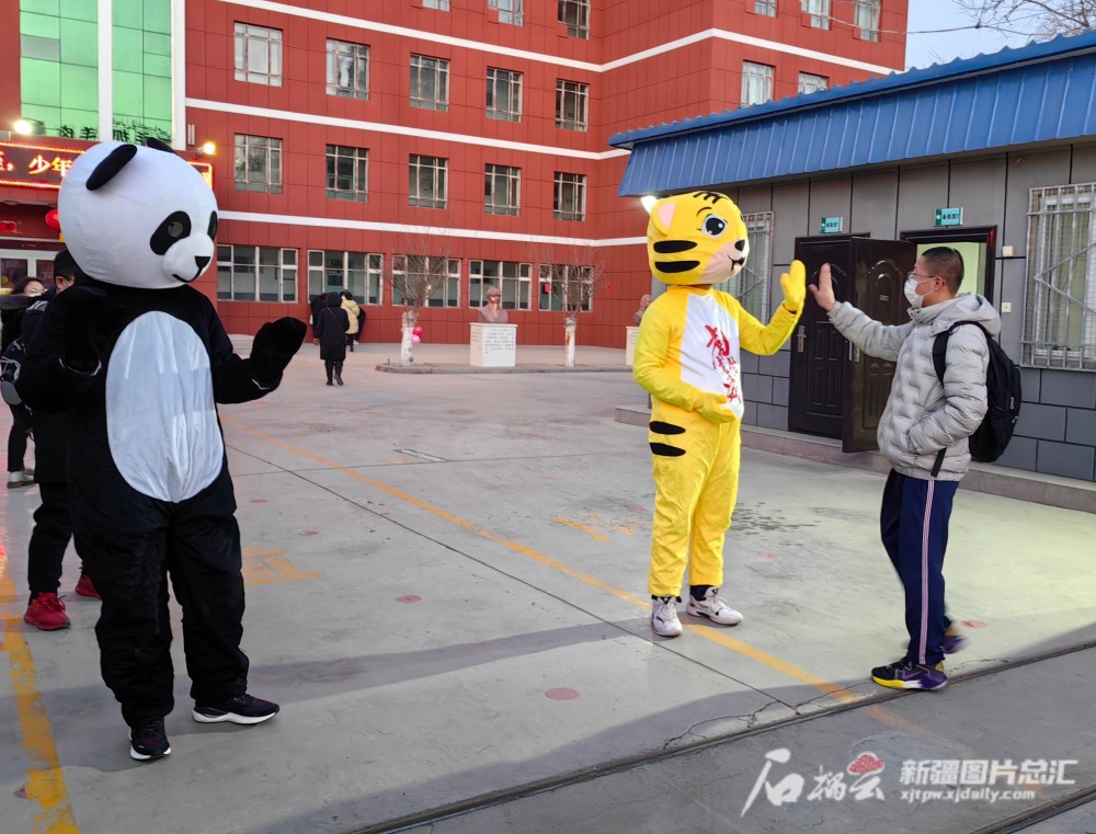 "开学首日,哈密市第六中学校园门口,见老师身着卡通服饰站迎接学生们