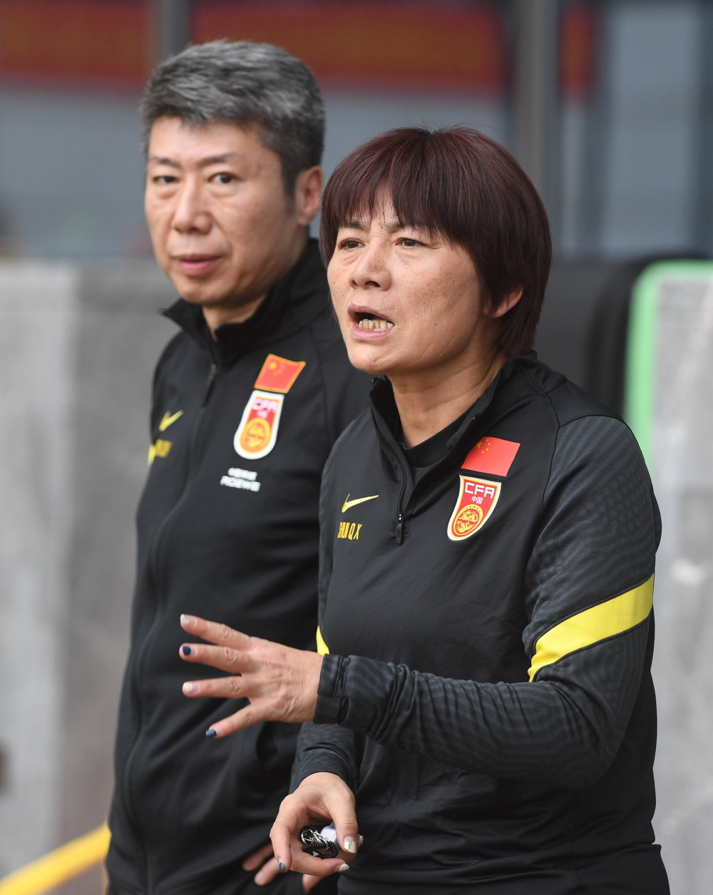 2月7日,中国女足主教练水庆霞(右)在训练中指导球员.