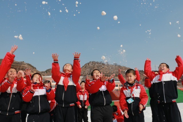 開學第一天,甘肅慶陽市鎮原縣蓮池小學學生在雪地玩耍.